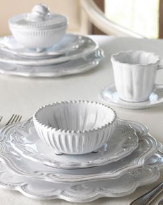 a white table topped with plates and silverware