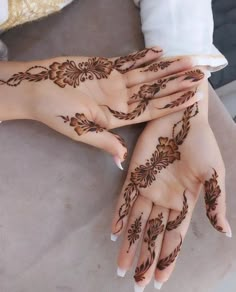 two hands with henna tattoos on them