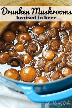 a blue pot filled with mushrooms and brown liquid on top of a white table cloth