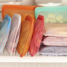 there are many plastic containers on the shelf in the refrigerator, and one is filled with food