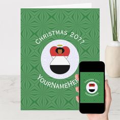 a hand holding up a christmas card with an app on it