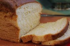 a loaf of bread sitting on top of a cutting board next to a slice of bread