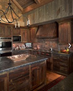 a large kitchen with wooden cabinets and granite counter tops, along with a chandelier hanging from the ceiling