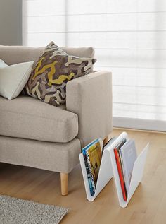 a living room with a couch, chair and magazine rack on the floor next to it