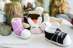 several stuffed animals sitting on top of a table next to each other with shoes around them