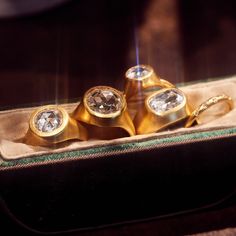 three gold rings sitting in a box on a table