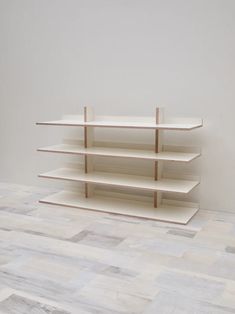 an empty shelf in the middle of a room with white walls and wood flooring