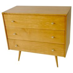 a wooden dresser with three drawers on one side and two small legs on the other