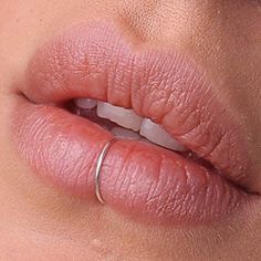 a woman's lips are shown with her ring on the tip of her lip