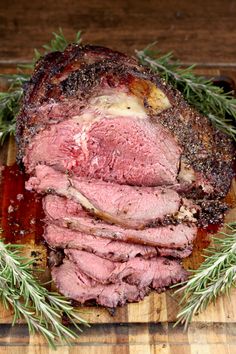 sliced roast beef on cutting board with rosemary sprigs and seasoning around it