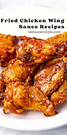 fried chicken wings on a white plate with sesame seeds