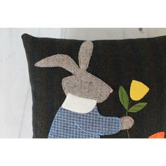 a decorative pillow with an image of a rabbit holding a flower in it's hand