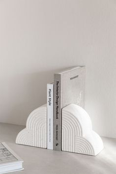 two bookends made out of white books sit on a table next to each other