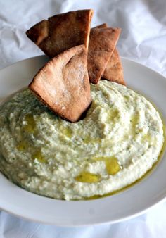 a white plate topped with guacamole and tortilla chips