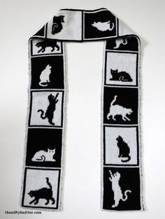 a black and white scarf with cats on it's sides, in the shape of squares