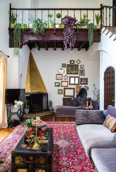 a living room filled with lots of furniture and pictures on the wall above it's fireplace