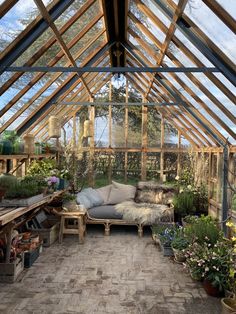 the inside of a greenhouse with lots of plants and flowers in it's windows