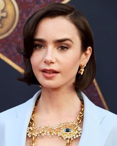 a close up of a person wearing a suit and necklace with an evil eye on it