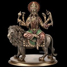 a statue of the hindu god sitting on top of a lion with two hands in each hand