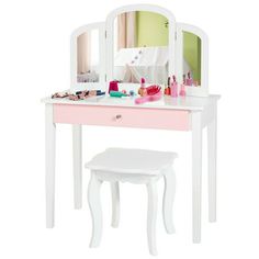 a pink and white vanity with mirror, stool and other items on the table in front of it