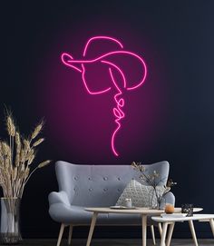 a living room with a couch, coffee table and neon pink hat on the wall