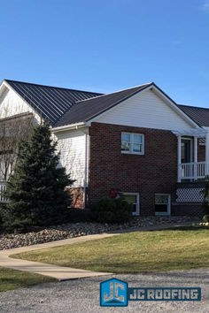 the front of a brick house with landscaping and trees