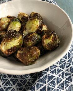 a white bowl filled with brussel sprouts on top of a table