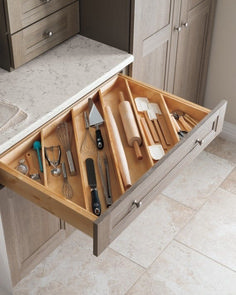 an open drawer with utensils in it