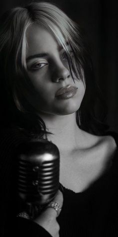 black and white photograph of a woman holding a microphone in front of her face,