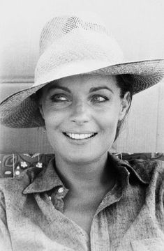 a black and white photo of a woman wearing a hat