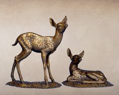 two bronze deer statues sitting next to each other