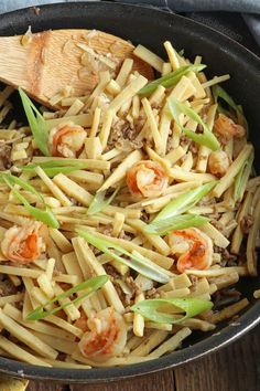 a skillet filled with pasta and shrimp