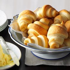 a bowl filled with rolls sitting on top of a table