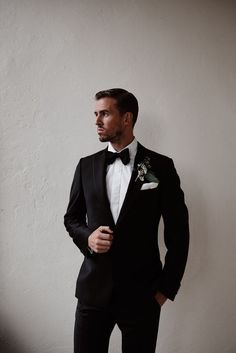 a man in a tuxedo poses for the camera