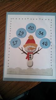 a christmas card with a snowman on the front and numbers in the middle, sitting on top of a wooden table