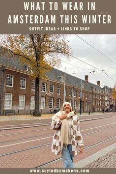 a woman walking down the street with text overlay saying what to wear in amsterdam this winter