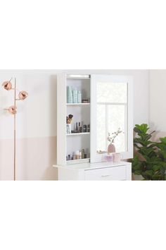 a bathroom with a white cabinet and mirror