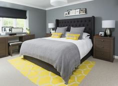 a bedroom with gray walls and yellow accents