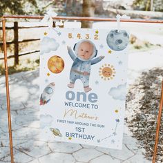 a sign for a baby's first birthday with an image of the astronaut on it