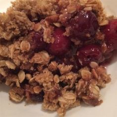 a white plate topped with granola and fruit