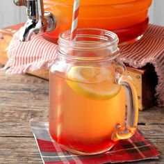 a glass jar filled with lemonade sitting on top of a wooden table