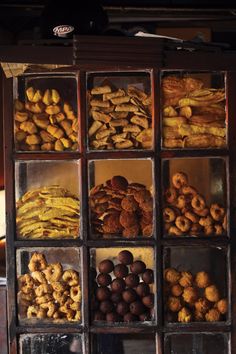 there are many different types of pastries in the bins on this shelf together