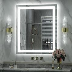 a bathroom with a sink, mirror and flowers on the counter in front of it