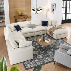 a living room filled with furniture and a large rug on top of a hard wood floor