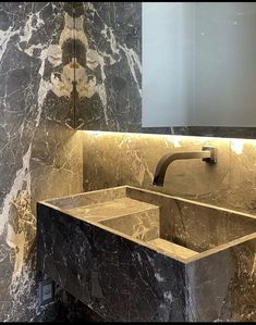 a bathroom sink sitting under a mirror in front of a wall mounted faucet