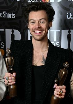 a man holding two awards in his hands