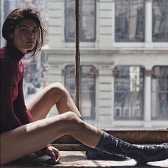 a woman sitting on top of a window sill