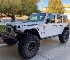 a white jeep parked in front of a house