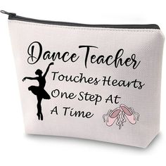 a white zippered bag with black lettering and a ballerina silhouette on the front