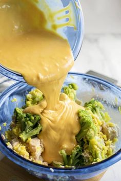 a person pouring sauce into a bowl filled with broccoli